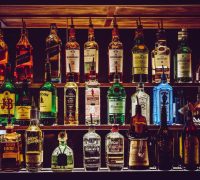 An array of various liquor bottles beautifully displayed on a bar shelf.